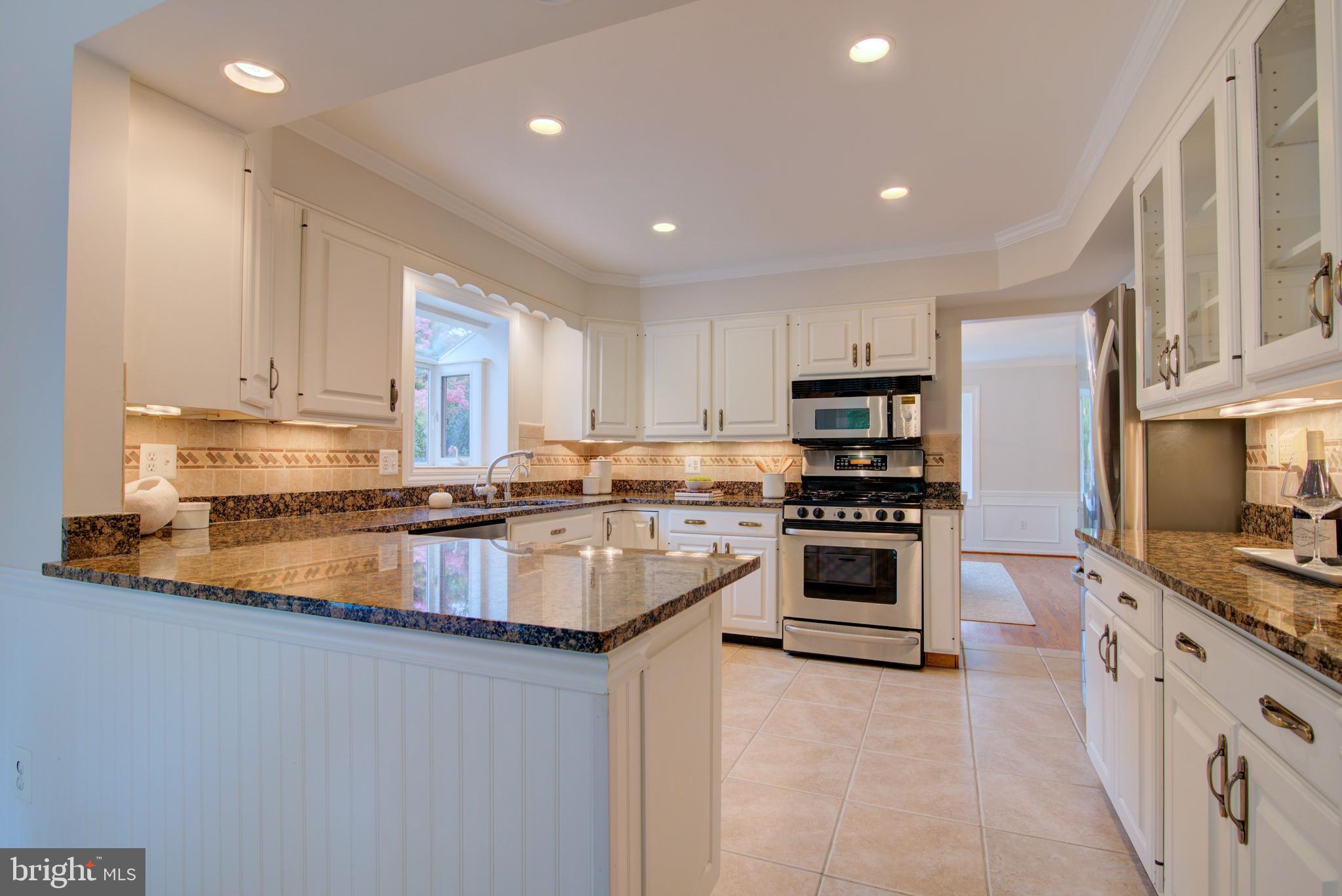 10405 Trumpeter Court Vienna, VA 22182 - Photo 18 of 43 a large kitchen with stainless steel appliances granite countertop a stove a sink and a microwave