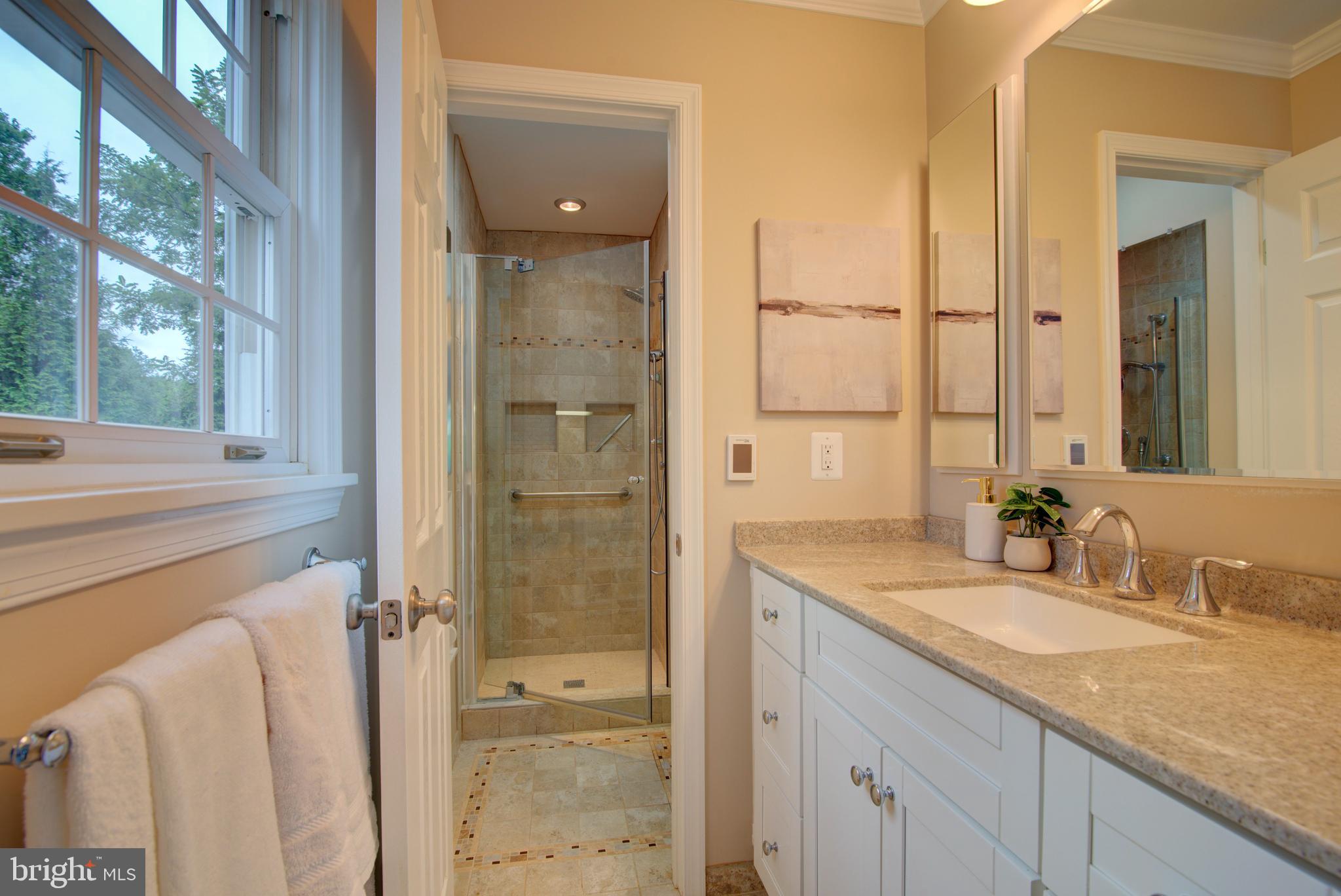10405 Trumpeter Court Vienna, VA 22182 - Photo 21 of 43 a bathroom with a granite countertop sink mirror and shower