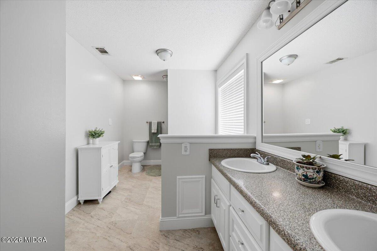 557 Aarons Circle Gray, GA 31032 - Photo 20 of 36 a bathroom with a granite countertop sink and a mirror