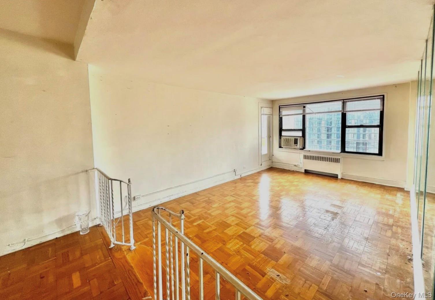98-22 63rd Drive, Unit 7B Queens, NY 11374 - Photo 6 of 10 a view of an empty room with a window