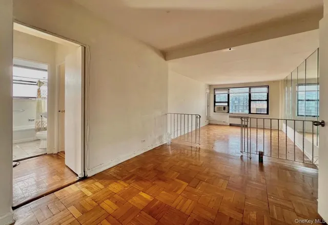a view of a room with wooden floor and a window