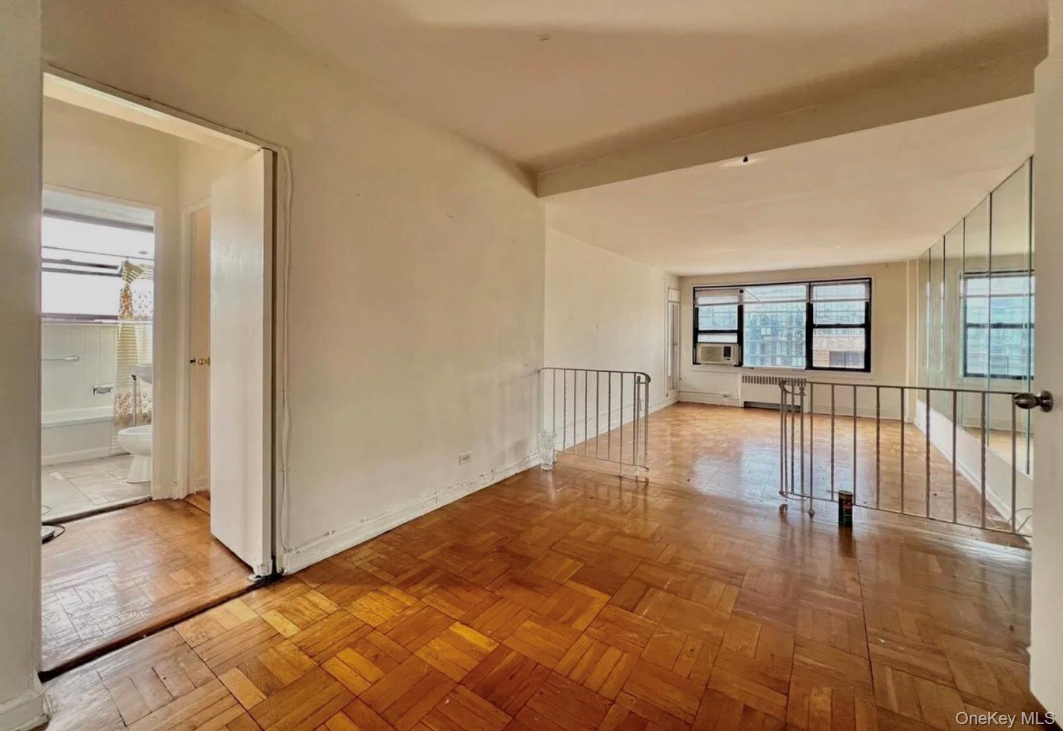 98-22 63rd Drive, Unit 7B Queens, NY 11374 - Photo 8 of 10 a view of a room with wooden floor and a window