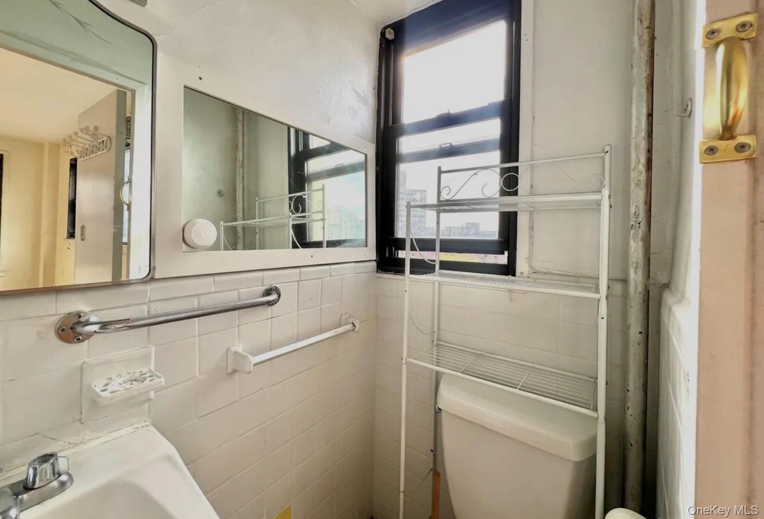 98-22 63rd Drive, Unit 7B Queens, NY 11374 - Photo 9 of 10 a bathroom with a sink and a mirror