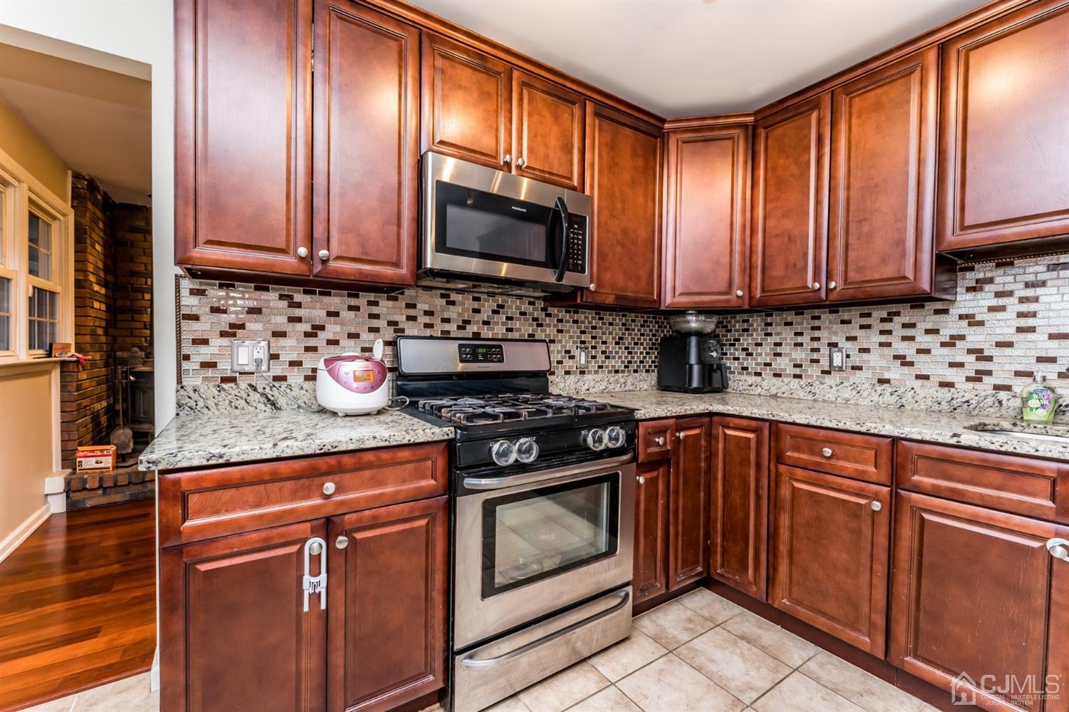 27 Fairfax Road Edison, NJ 08817 - Photo 8 of 25 a kitchen with granite countertop wooden cabinets stainless steel appliances and a sink