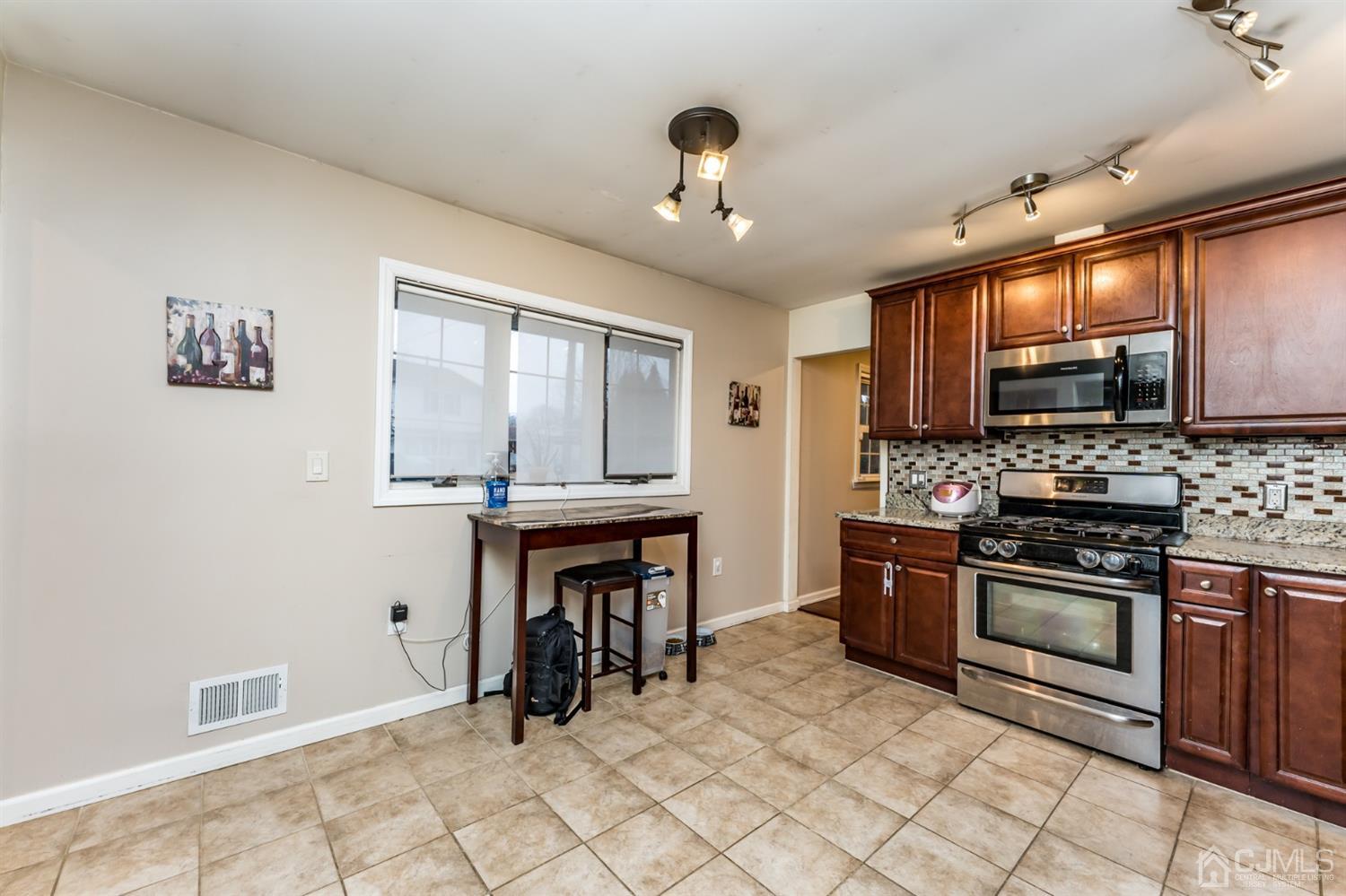 27 Fairfax Road Edison, NJ 08817 - Photo 10 of 25 a kitchen with stainless steel appliances granite countertop a stove top oven a sink dishwasher and a refrigerator with wooden floor