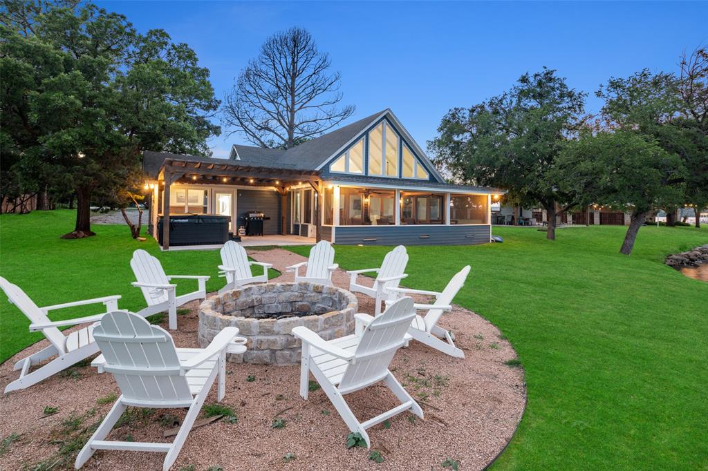 a view of house with a yard chairs and table in patio