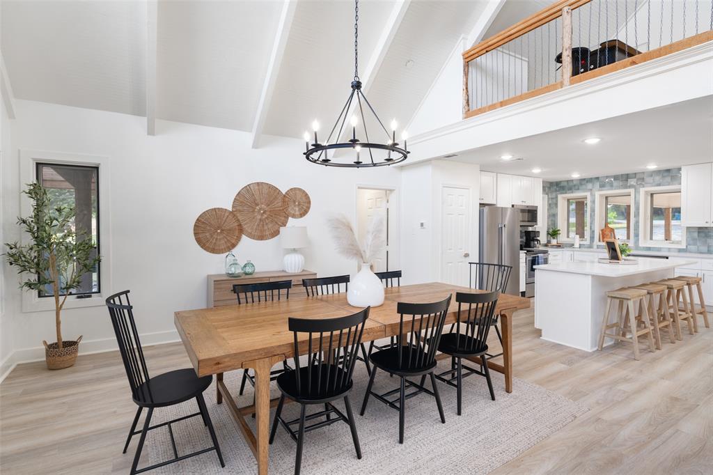 1907 Buck Run Graford, TX 76449 - Photo 7 of 33 a dining room with wooden floor a chandelier a wooden table and chairs