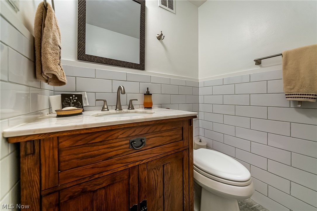 13800 Fairhill Road, Unit 306 Cleveland, OH 44120 - Photo 32 of 48 Half bathroom with vanity, tile walls, and a wainscoted wall