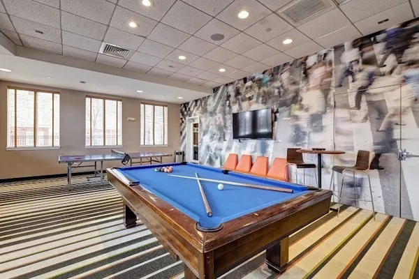 a room with pool table flat screen tv and windows