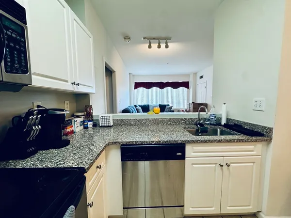 a kitchen with granite countertop a sink and cabinets