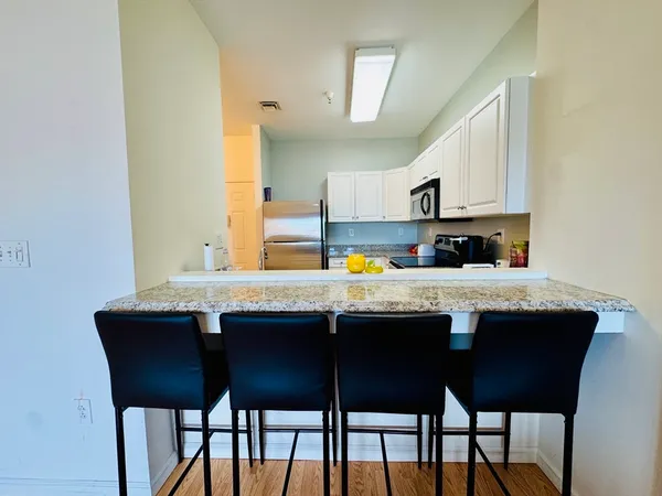 a kitchen with stainless steel appliances granite countertop a sink and white cabinets