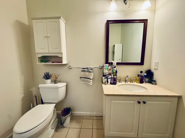 a bathroom with a toilet sink vanity and mirror