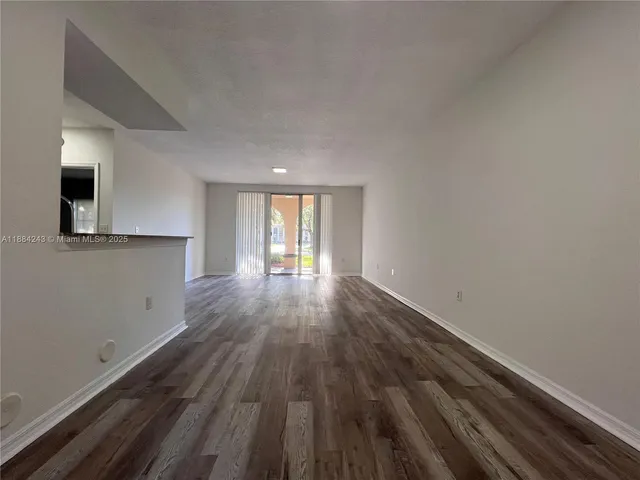a view of a room with wooden floor and window