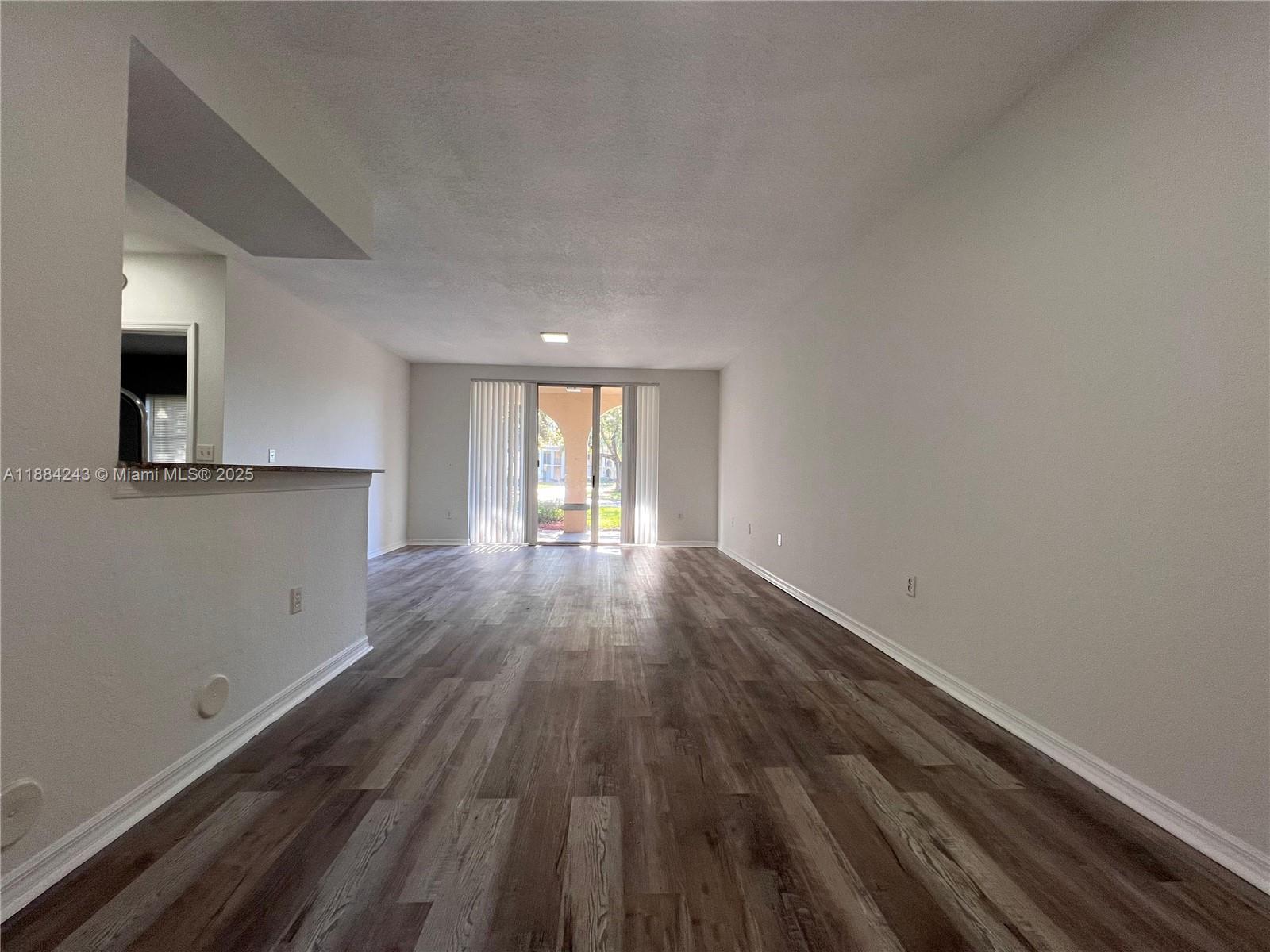 2400 Centergate Drive, Unit 102 Miramar, FL 33025 - Photo 4 of 12 a view of a room with wooden floor and window