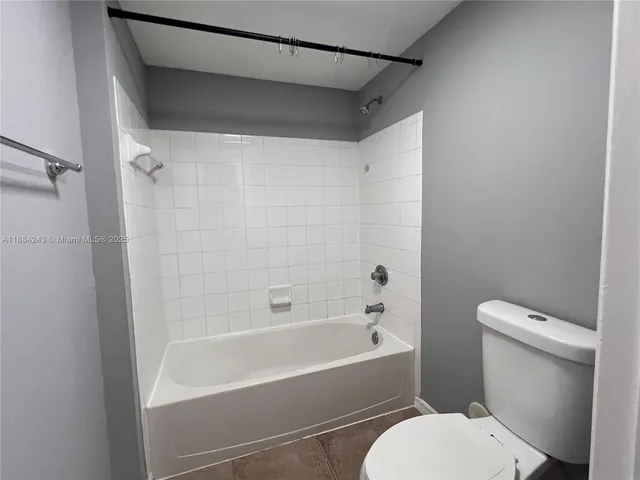 a white toilet sitting next to a bath tub