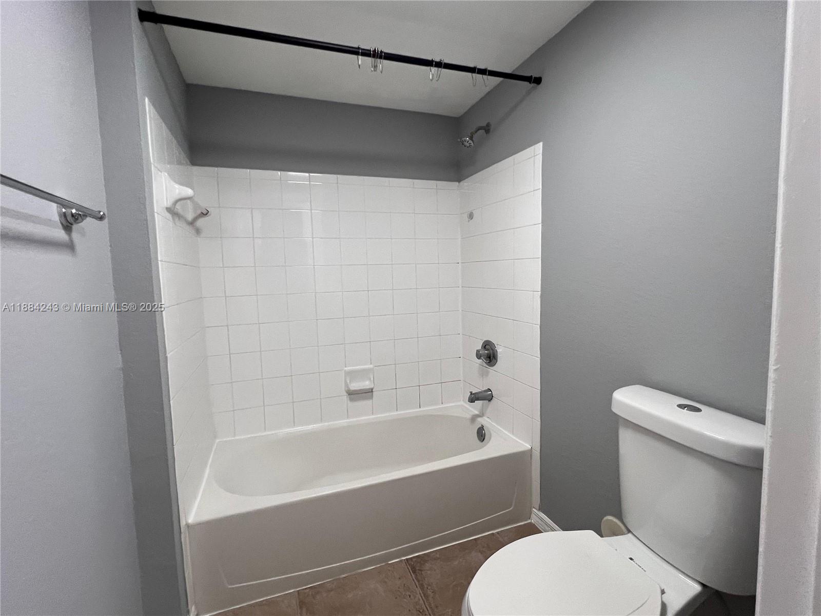 2400 Centergate Drive, Unit 102 Miramar, FL 33025 - Photo 8 of 12 a white toilet sitting next to a bath tub