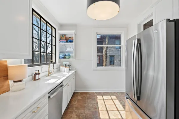 a kitchen with white cabinets and stainless steel appliances