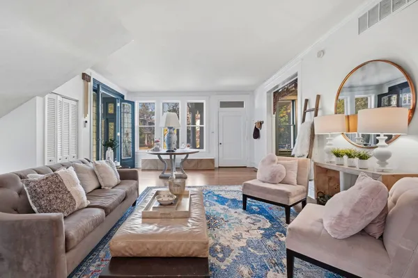 a living room with furniture a fireplace and a chandelier