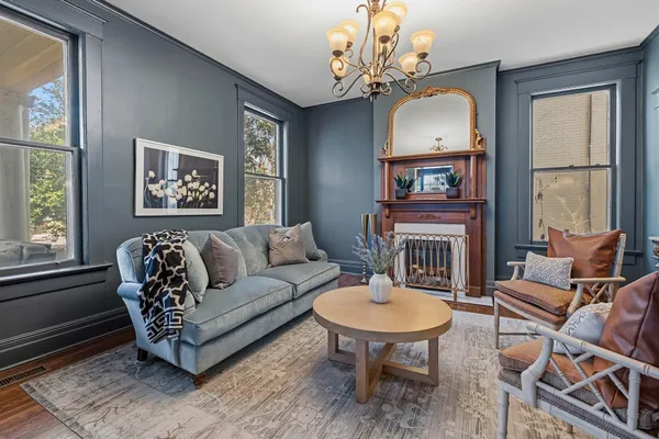 a view of a livingroom and dining room with wooden floor windows and a chandelier