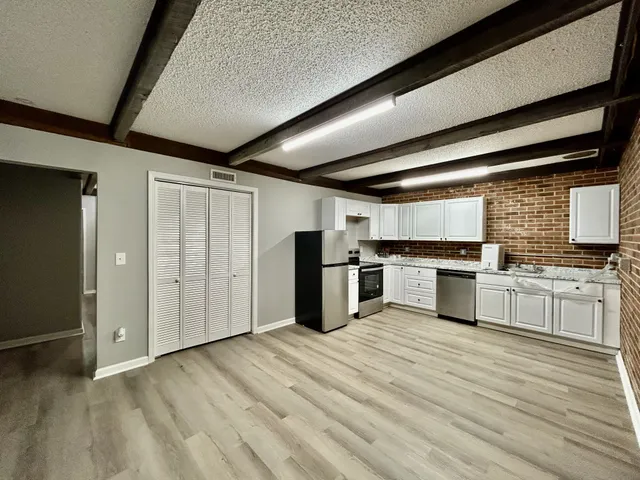 a kitchen with stainless steel appliances kitchen island granite countertop a refrigerator and a stove top oven