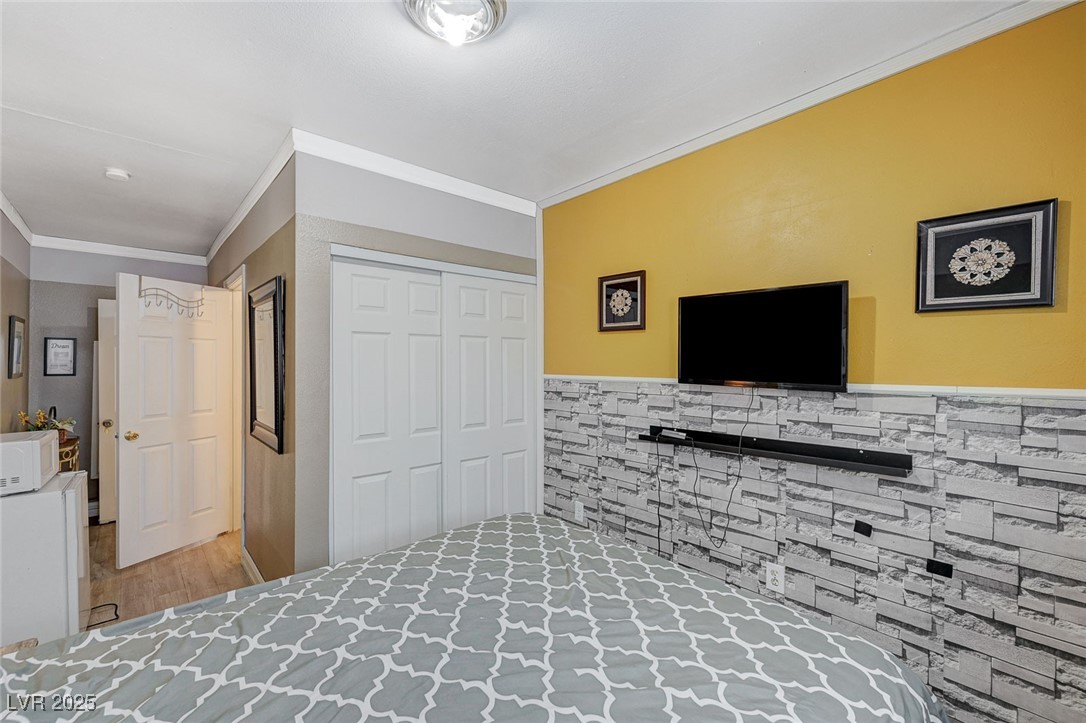 3266 Mountain Spring Road Las Vegas, NV 89146 - Photo 33 of 49 Bedroom with wood finished floors, a closet, and crown molding