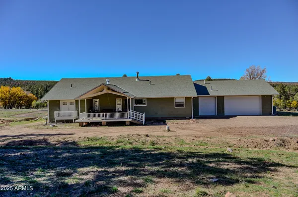 a front view of a house with yard and mountain view in back