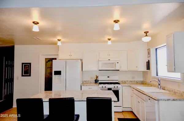 a kitchen with stainless steel appliances granite countertop a sink and cabinets