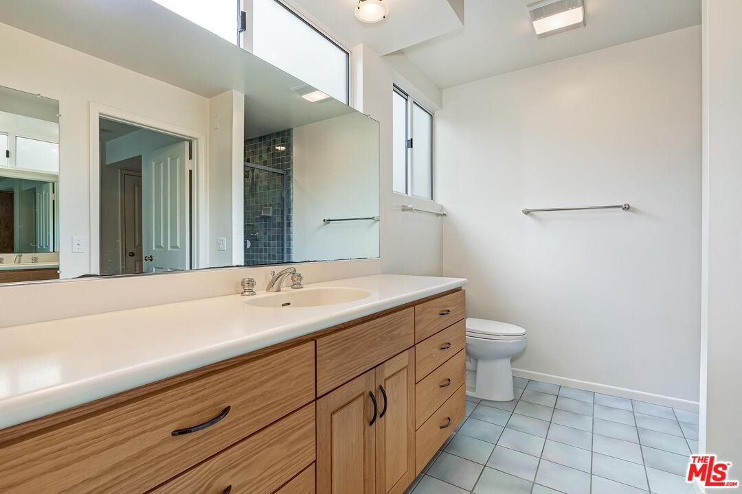 18409 Wakecrest Drive Malibu, CA 90265 - Photo 27 of 32 a bathroom with a sink a toilet and a mirror