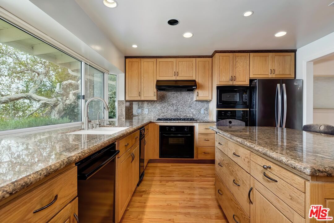 18409 Wakecrest Drive Malibu, CA 90265 - Photo 9 of 32 a large kitchen with stainless steel appliances granite countertop a stove a sink and a refrigerator