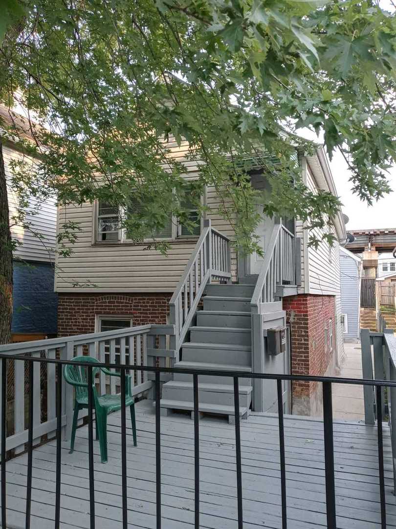 a view of house with wooden deck and furniture
