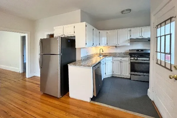 a kitchen with a refrigerator sink and wooden floor