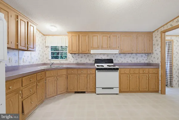 a kitchen with granite countertop white cabinets sink and stainless steel appliances