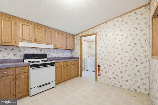 a kitchen with a sink cabinets and a stove top oven