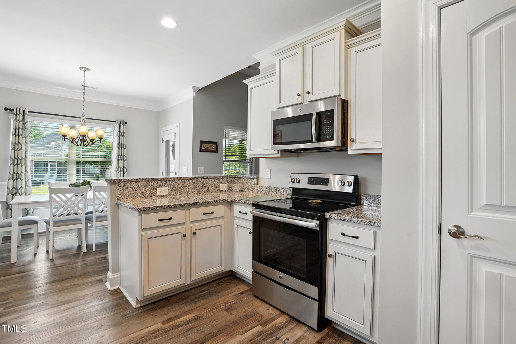 116 Colonade Court Benson, NC 27504 - Photo 14 of 37 a kitchen with stainless steel appliances granite countertop a stove top oven a sink dishwasher a dining table and chairs with wooden floor