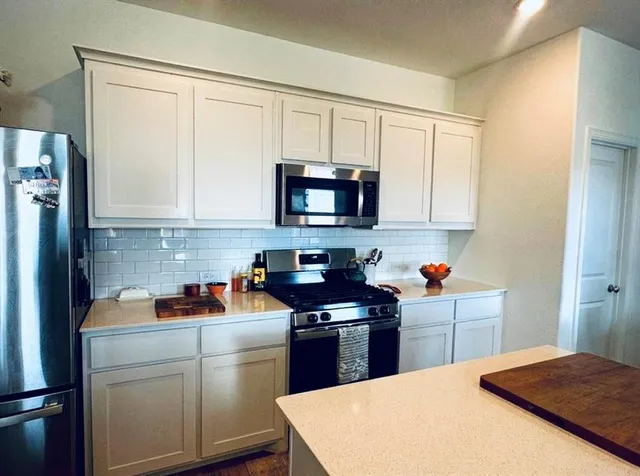 a kitchen with stainless steel appliances granite countertop a refrigerator sink and cabinets