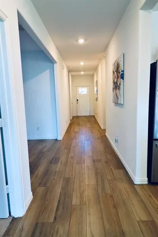 a view of a hallway with wooden floor