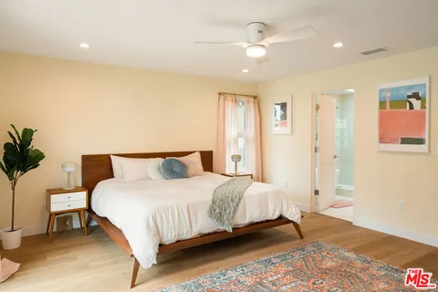 a bedroom with a bed and a potted plant