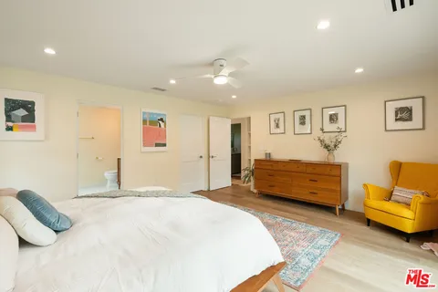 a bedroom with a bed couch and a window