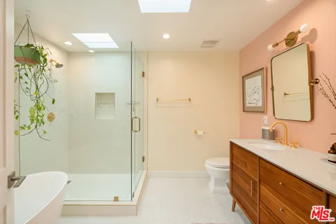 a bathroom with a granite countertop sink a toilet and shower