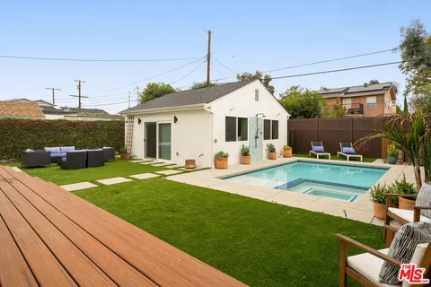a view of a house with a backyard patio and swimming pool