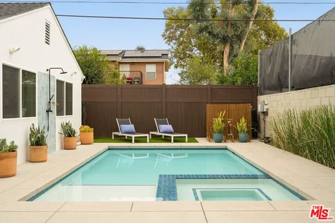 a view of a patio with table and chairs potted plants with wooden floor and fence