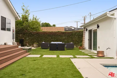 a view of a patio with a table chairs and a yard