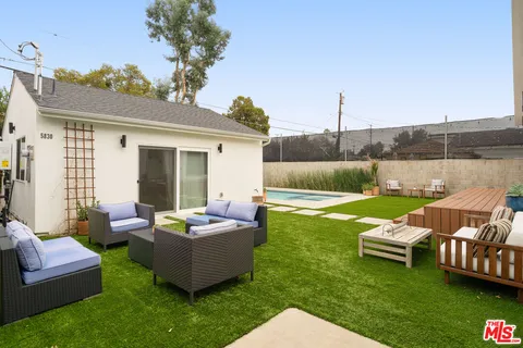 a view of a patio with couches chairs and a yard