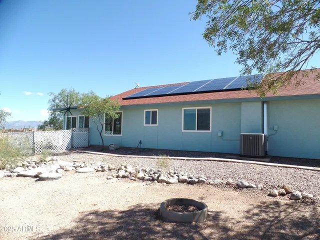 an empty room with wooden floor fireplace and windows