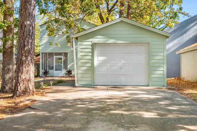 a view of the house with a yard and large tree