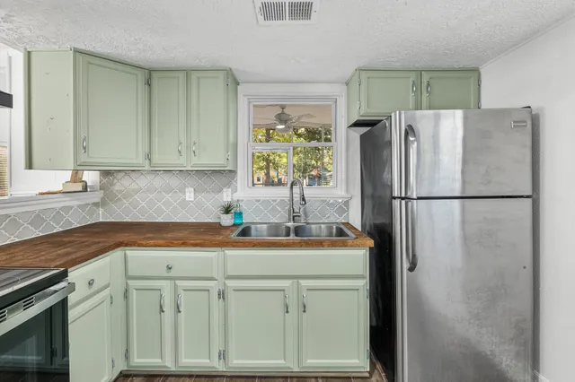 a kitchen with stainless steel appliances granite countertop a refrigerator a sink and dishwasher