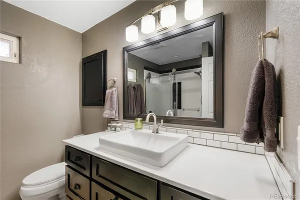 a bathroom with a sink a toilet and a mirror