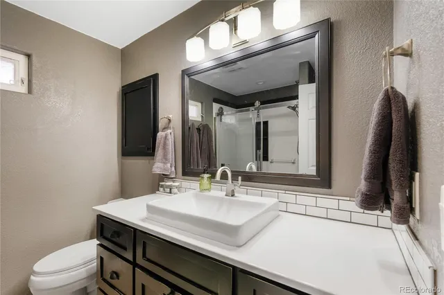 a bathroom with a sink a toilet and a mirror