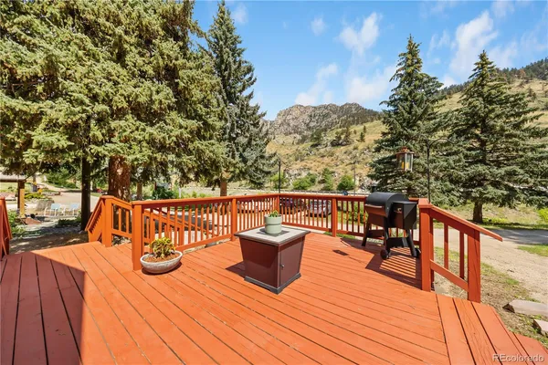 a view of a patio with table and chairs potted plants and large tree