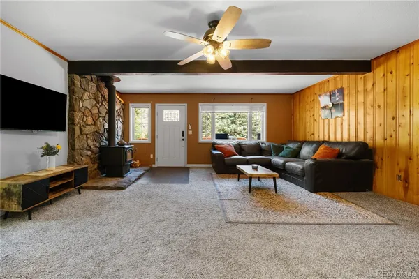 a living room with furniture a flat screen tv and a window